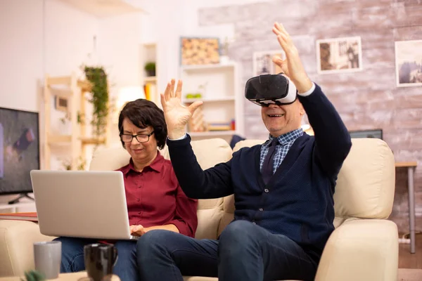 Idoso idoso aposentado homem usando realidade virtual headset em seu aconchegante apartamento — Fotografia de Stock
