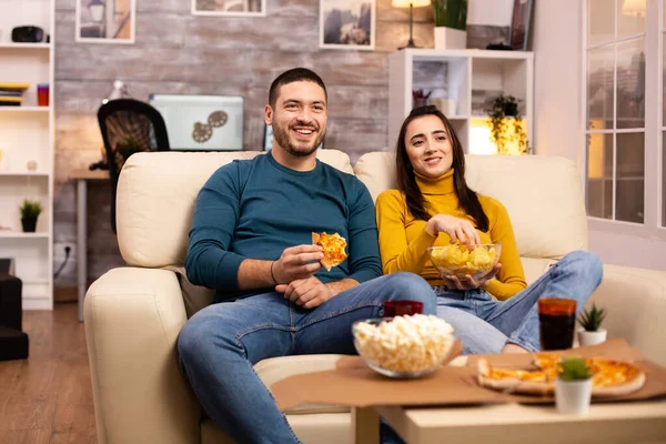 Belo jovem casal assistindo TV e comer fast food takeaway — Fotografia de Stock