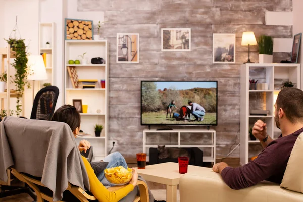 Zadní pohled na pár v obývacím pokoji sledování filmu na televizoru — Stock fotografie