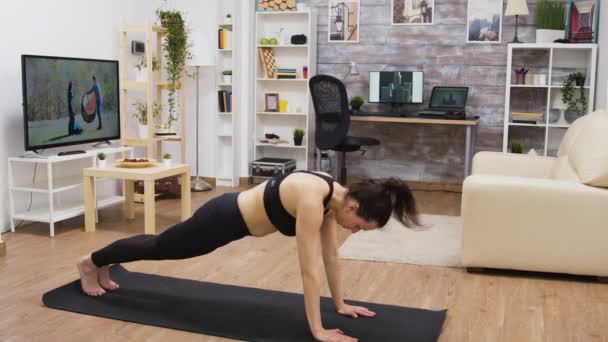 Красивая молодая женщина делает упражнения, чтобы облегчить боль в спине — стоковое видео