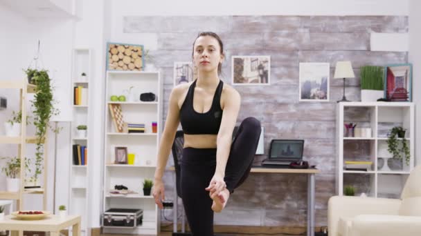 Young woman standing in one foot on mat — Stock Video