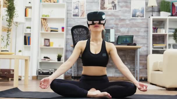 Vacker ung kvinna som bär virtuella verklighetsglasögon som gör yoga — Stockvideo