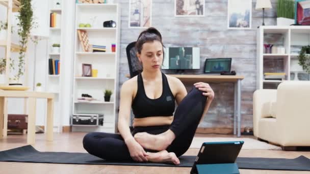 Joven mujer caucásica en ropa deportiva practicando yoga — Vídeo de stock