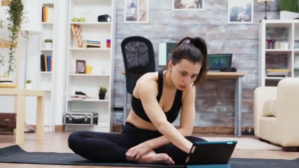 Attraktive Frau sucht Yoga-Übungen auf dem Tablet — Stockvideo
