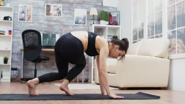 Visão lateral da jovem mulher fazendo treinamento de ioga — Vídeo de Stock