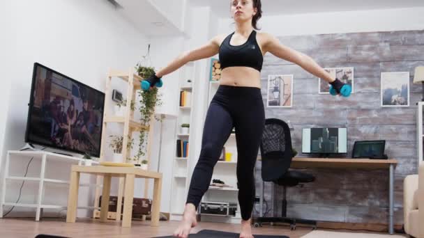 Jonge vrouw houden halters terwijl het doen van lunge workout — Stockvideo