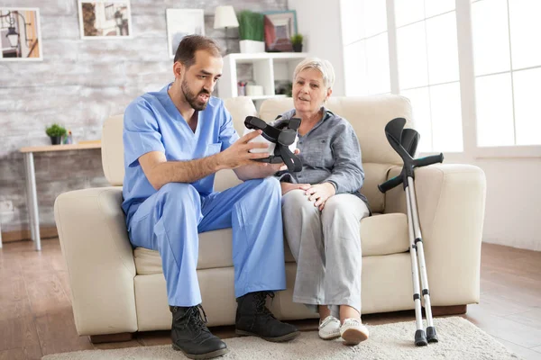 Giovane medico seduto sul divano in casa di cura — Foto Stock