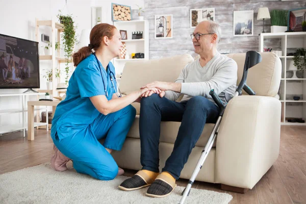 Old man with glasses sitting on couch in nursing room — Stock Photo, Image