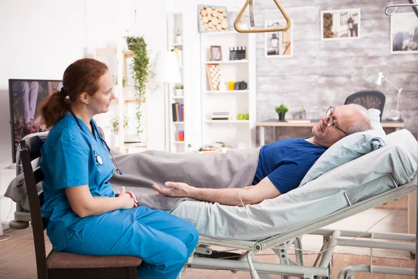 Homme âgé en maison de retraite parlant avec une infirmière — Photo