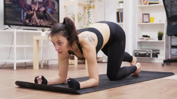 Красивая молодая женщина делает упражнения на доске — стоковое видео