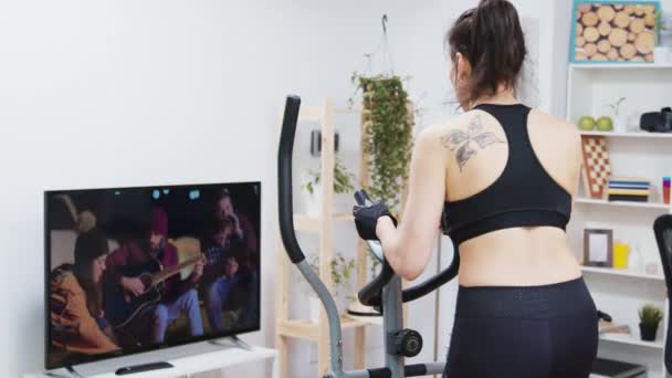 Vista posterior de la mujer joven haciendo un entrenamiento en casa — Vídeos de Stock