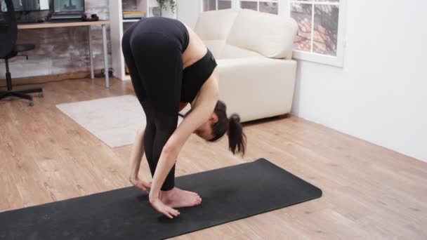 Chica deportiva haciendo un ejercicio de yoga en casa — Vídeo de stock