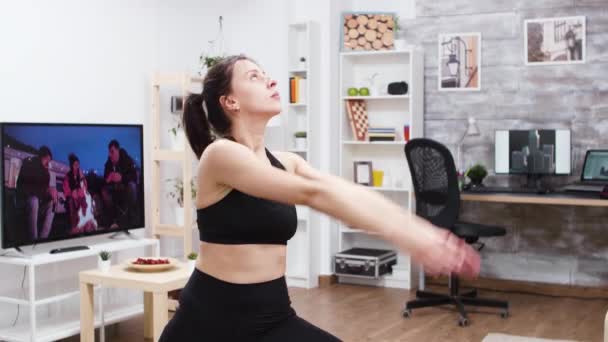 Middenhoek van jonge vrouw die yoga thuis beoefent — Stockvideo