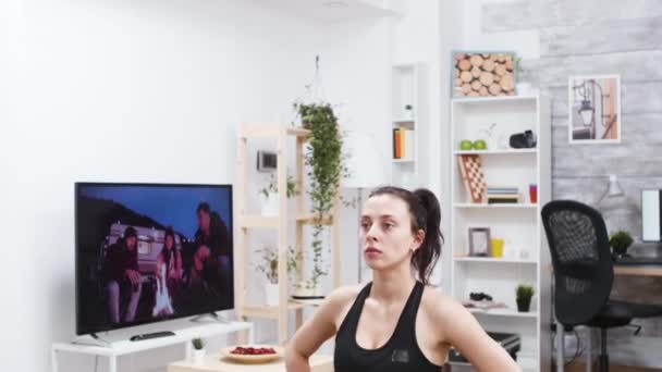 Bare foot young woman doing lunges in living room — 비디오