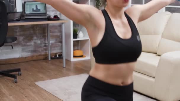 Mujer joven haciendo un entrenamiento de cuerpo completo en casa — Vídeo de stock