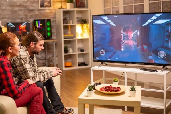 Paar videospelletjes spelen op groot scherm TV in de woonkamer laat op de avond — Stockfoto