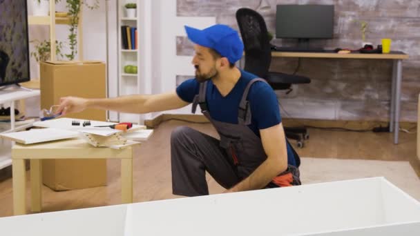 Male worker wearing protection glasses before furniture assembly — Stock Video