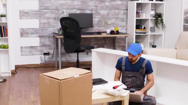 Mężczyzna pracownik w czapce podczas korzystania z jego laptopa — Wideo stockowe