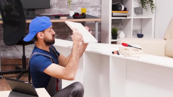 Aantrekkelijke klusjesman monteert nieuwe meubels — Stockvideo
