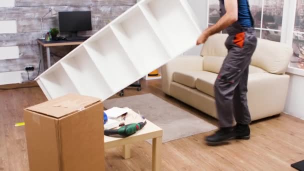 Работник-мужчина проверяет новую мебель после того, как закончил ее сборку — стоковое видео