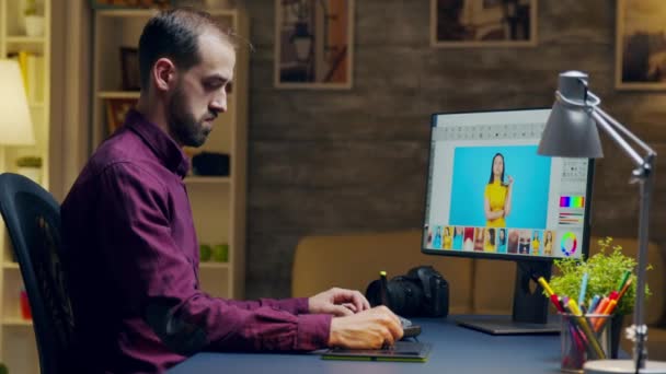 Fotografer yang melihat lebih dekat ke komputer ketika menyentuh kembali foto — Stok Video