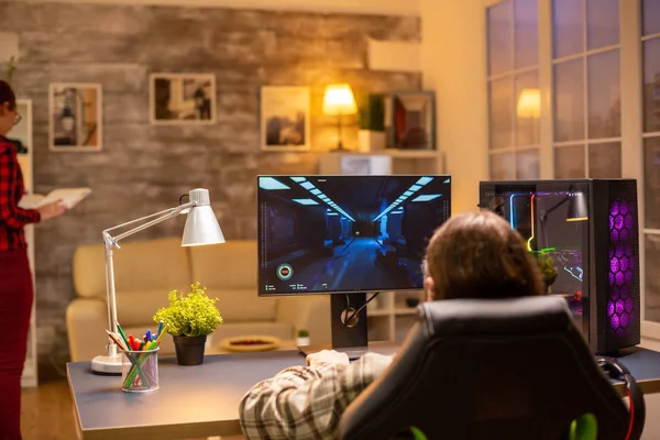Widok z tyłu profesjonalnego gracza wideo grającego na potężnym komputerze późno w nocy w salonie — Zdjęcie stockowe