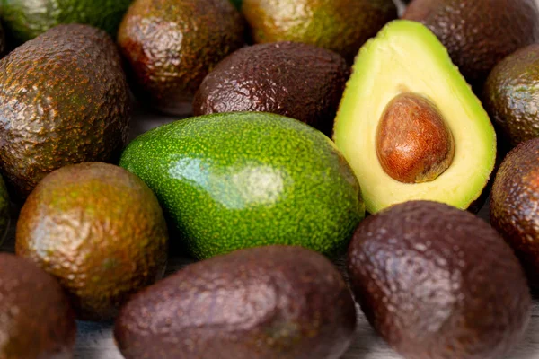 Нарезанный плод авокадо рядом с другим — стоковое фото