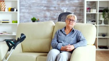 Kanepede oturan yalnız yaşlı kadının fotoğrafını yakınlaştır.