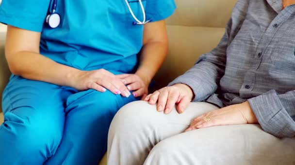 Nahaufnahme einer Pflegerin in Pflegeheim, die Seniorin an der Hand hält — Stockvideo