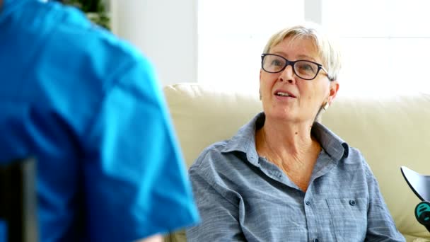 老年老妇人坐在养老院的沙发上与医生交谈 — 图库视频影像
