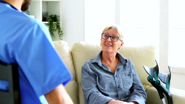 Mężczyzna pielęgniarka i starsza kobieta w rozmowa — Wideo stockowe