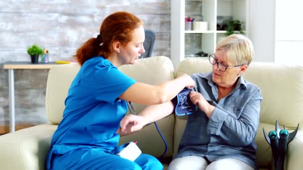 Médico feminino tomando pressão arterial de mulher idosa — Vídeo de Stock
