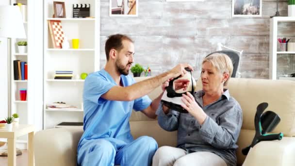 Médico masculino en residencia de ancianos ayudando a una mujer mayor — Vídeo de stock