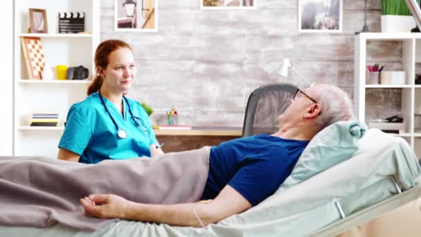 Enfermo anciano conversando con una enfermera caucásica — Vídeos de Stock