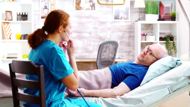 Verpleegster in bejaardentehuis luisteren naar oude zieke man hart kraal — Stockvideo