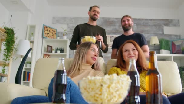 Lage hoek uitzicht van vrienden kijken naar een voetbalwedstrijd — Stockvideo