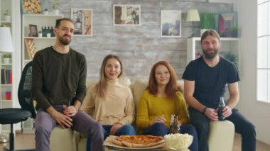 Adam gülüyor ve pizza dilimine uzanıyor.