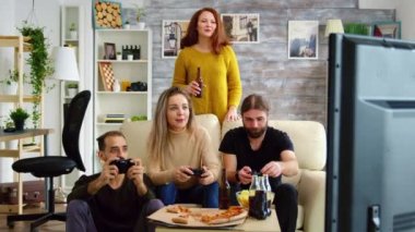 Video oyunu oynarken cips yiyen genç adam