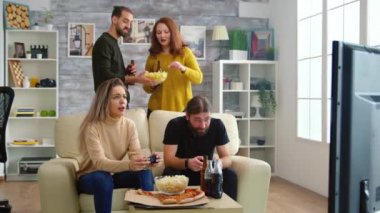 Video oyunlarını kız arkadaşına karşı kazandıktan sonra mutlu bir genç adam.