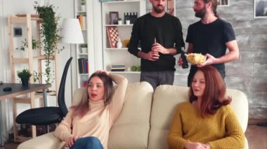 İki genç adam bira içerken sohbet ediyorlar.