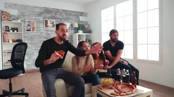 Elinde bir dilim pizza tutan genç adam kendini yere atıyor. — Stok video