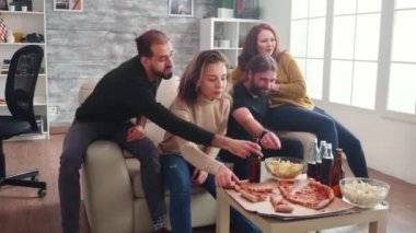 Bir grup beyaz arkadaş kanepede oturmuş televizyon seyrediyorlar.