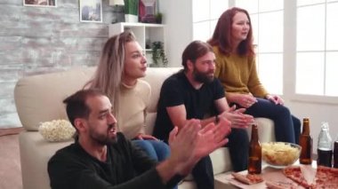 Genç adam futbol maçı izlerken alkışlıyor.