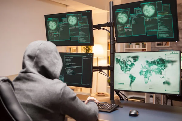Pirata informático peligroso con una sudadera con capucha al plantar un malware — Foto de Stock