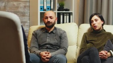 Genç adam koltukta ağır ağır oturuyor.