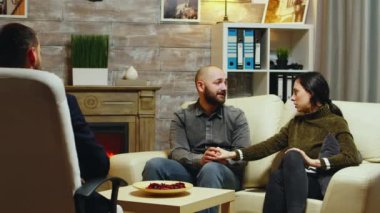 Kanepede el ele tutuşan genç çift.