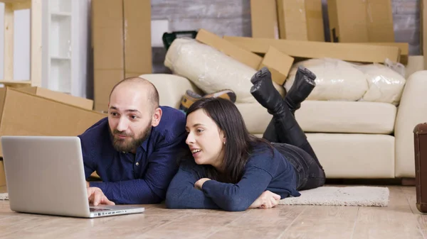 Счастливая пара, сидящая на полу своей новой квартиры — стоковое фото