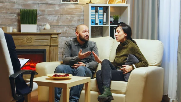 Casal sentado no sofá discutindo uns com os outros — Fotografia de Stock
