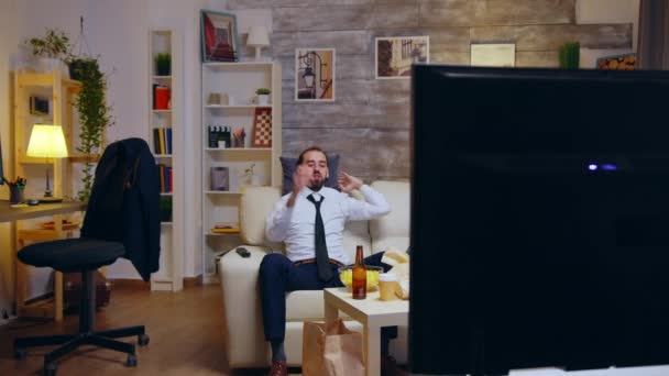 Üzletember nyakkendővel pihentető kanapén egy hosszú munkanap után — Stock videók