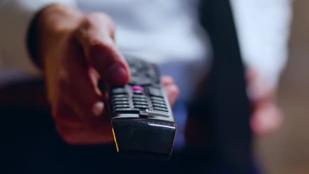 Close up of businessman relaxing after work using tv remote control — Stock video